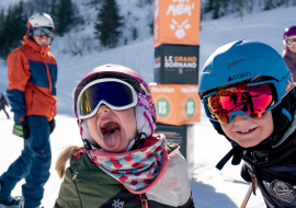 Enfants s'amusant et grimaçant sur les espaces débutants du domaine de ski alpin du Grand-Bornand