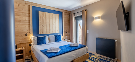 Chambre en bois et peinture bleue et moquette bleue et beige.