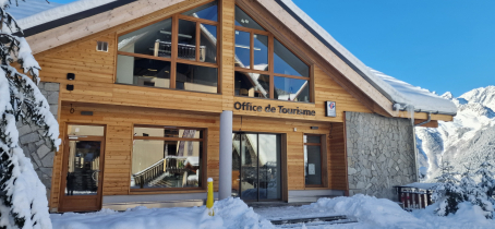 Facade de l'Office de tourisme enneigée sous un ciel bleu