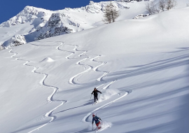 2 skieurs évoluant en ski hors pistes, sortie encadrée par un moniteur de l'école SNOCOOL