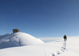 Sortie raquettes dans un décor hivernal sur les hauteurs du domaine skiable de Sainte Foy Tarentaise, accompagnée par un guide d'Evolution 2