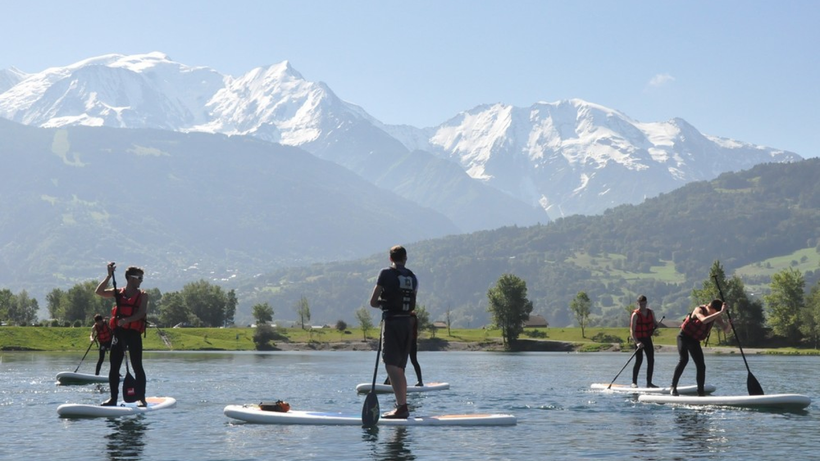 Personnes pratiquant du stand up paddle face au Mont Blanc