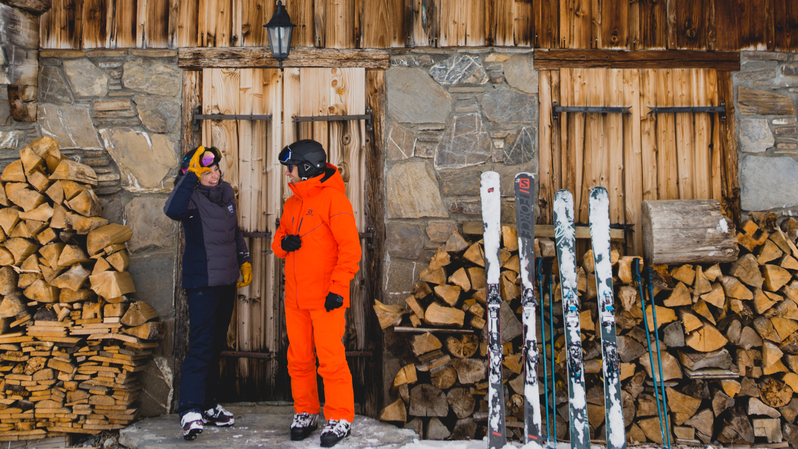 deux skieurs devant un chalet en hiver