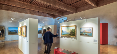 Visiteurs dans une salle d'exposition de tableaux de paysages