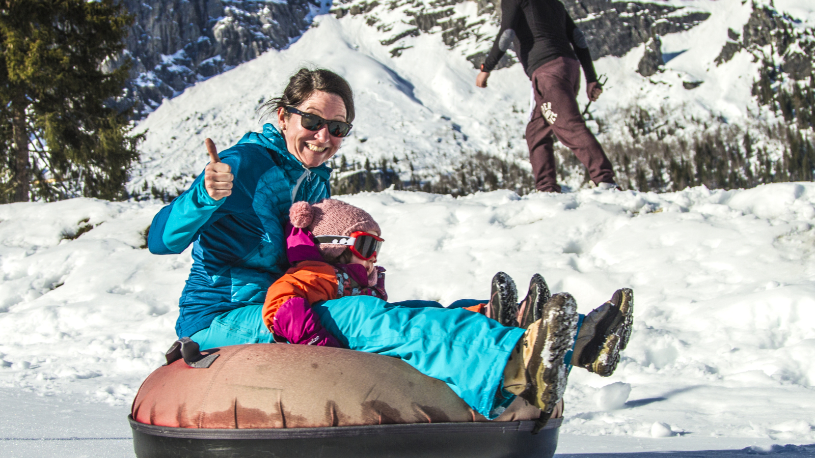 Family riding a snowtubing sledge