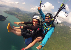 Tandem paragliding flight above lake Annecy
