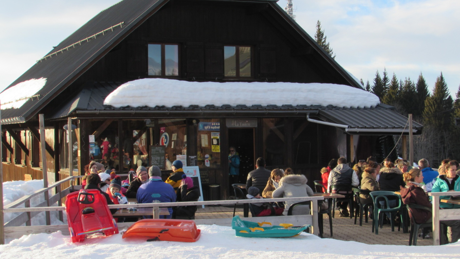 Skiers on the terrace in front of the La Tanière restaurant