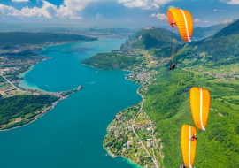 three paragliders above lake Annecy