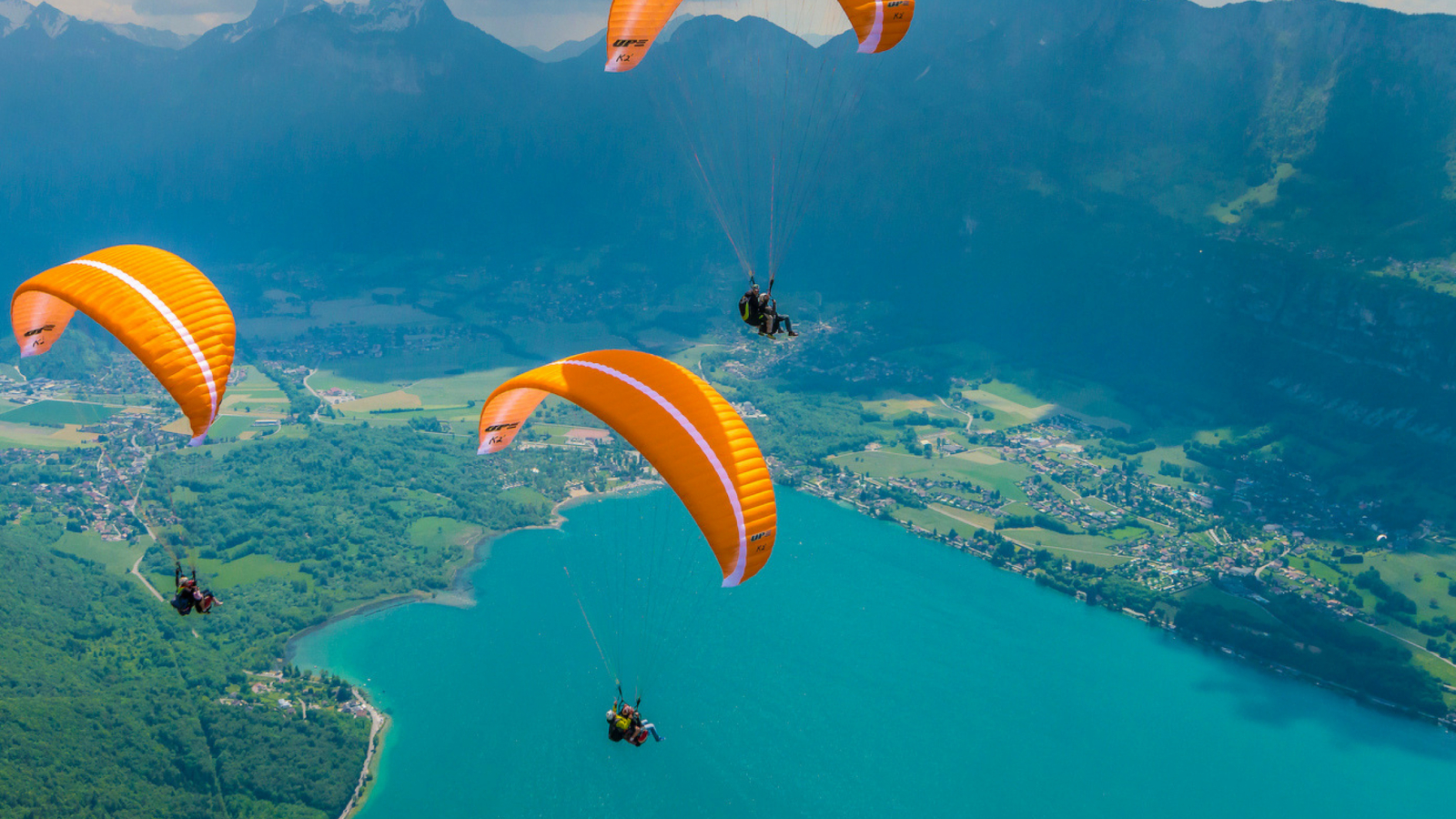 three paragliders above lake Annecy
